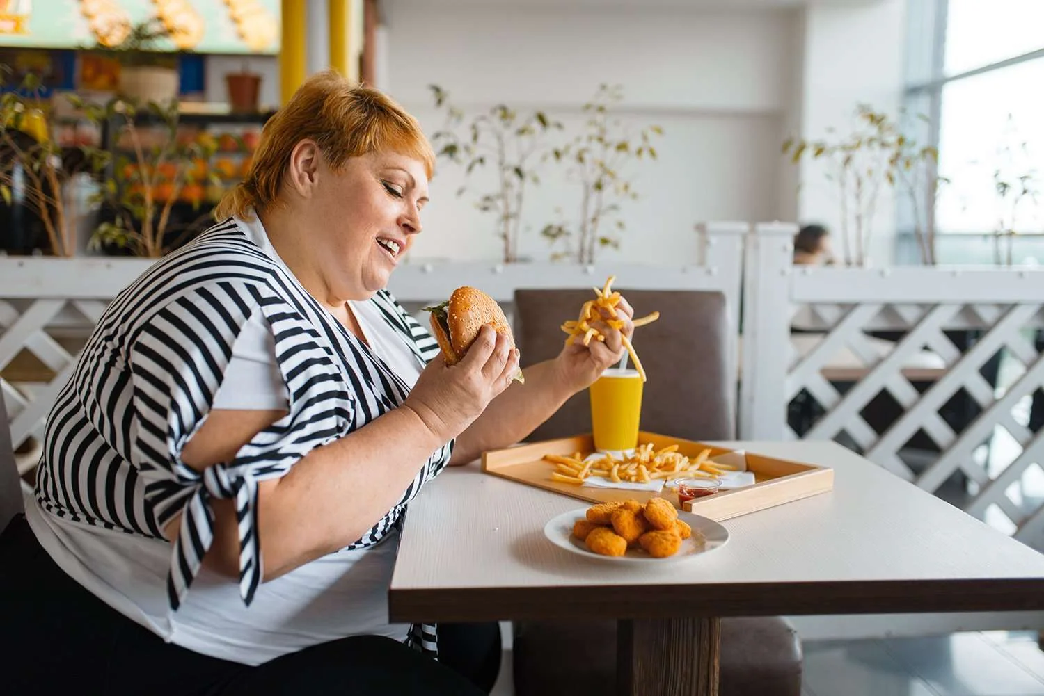 Obese woman eating a hamburger