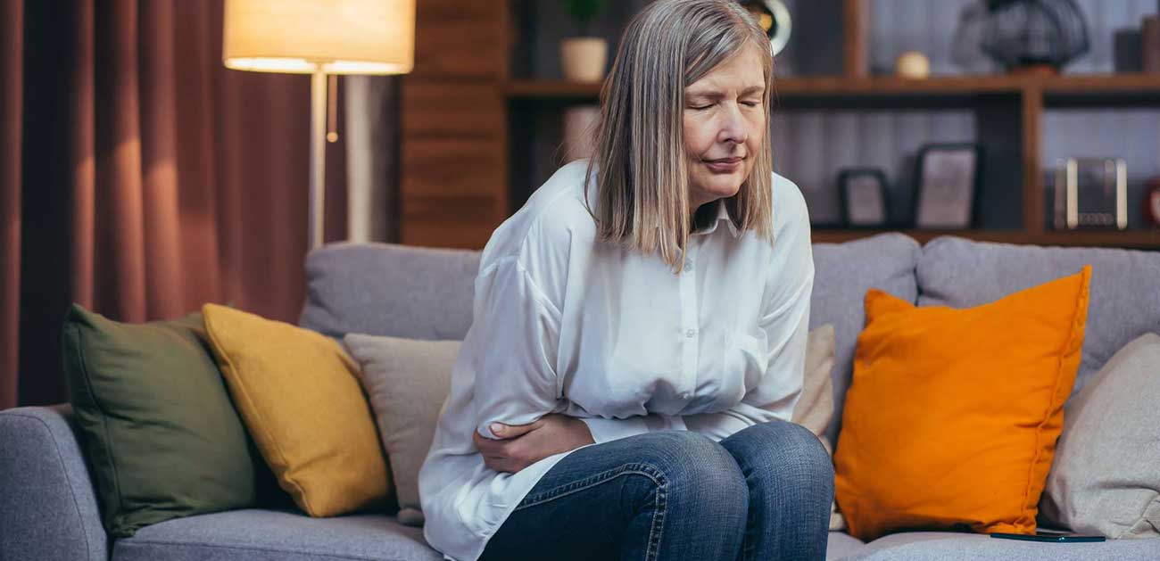 Woman holding her stomach from hunger pants