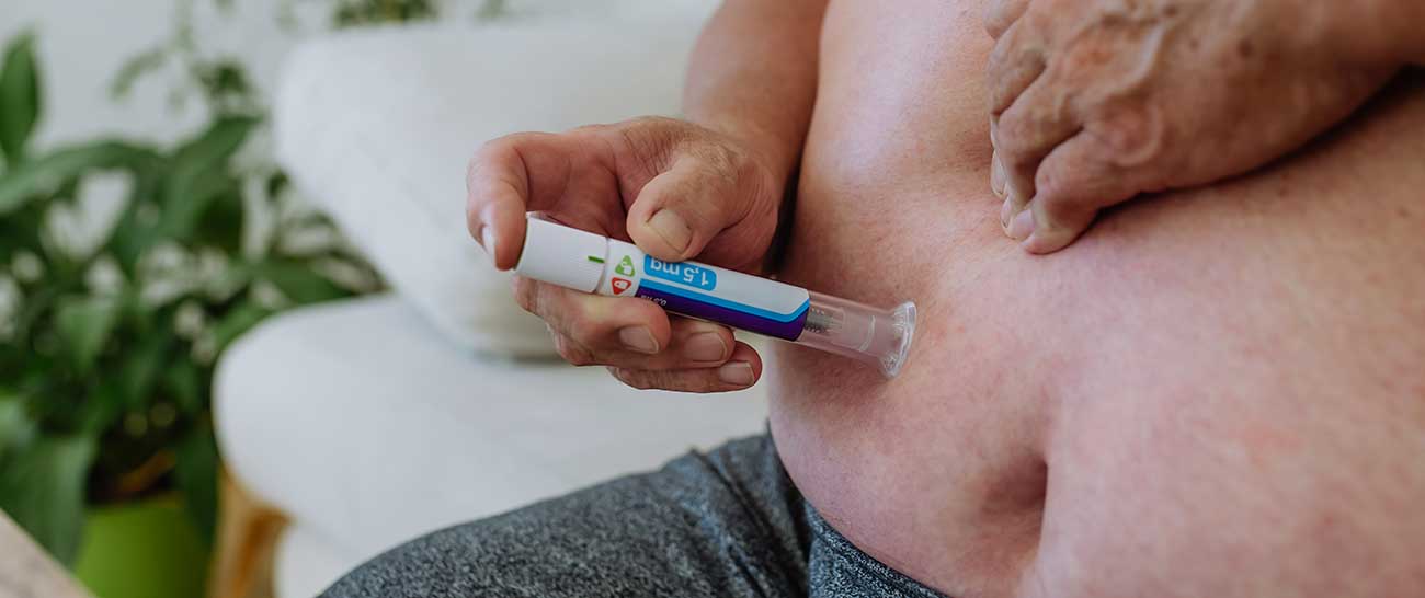 Person injecting Trulicity pen into stomach