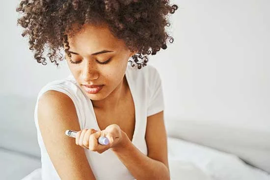 Woman injecting insulin into her upper arm
