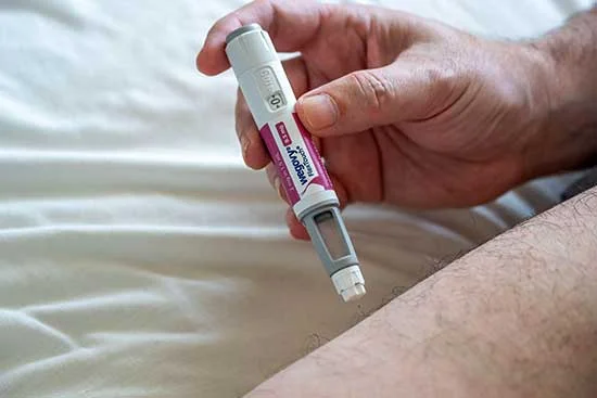 Person injecting Wegovy into their thigh